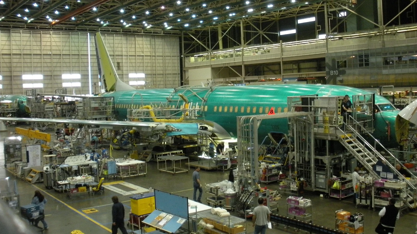 Archive photograph of a green Boeing 737 fuselage, assembly stands and workers inside the Renton factory in May 2010.